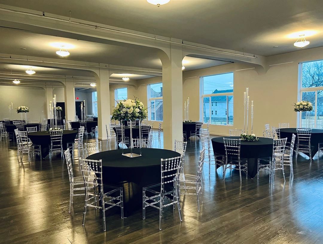 The Kercheval Gallery set with round tables, black linens, and tall centerpieces